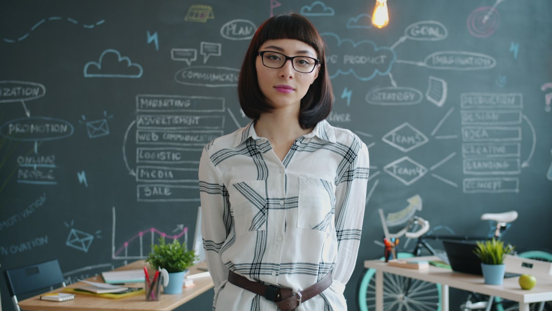 Woman standing in front of a chalkboard with diagrams