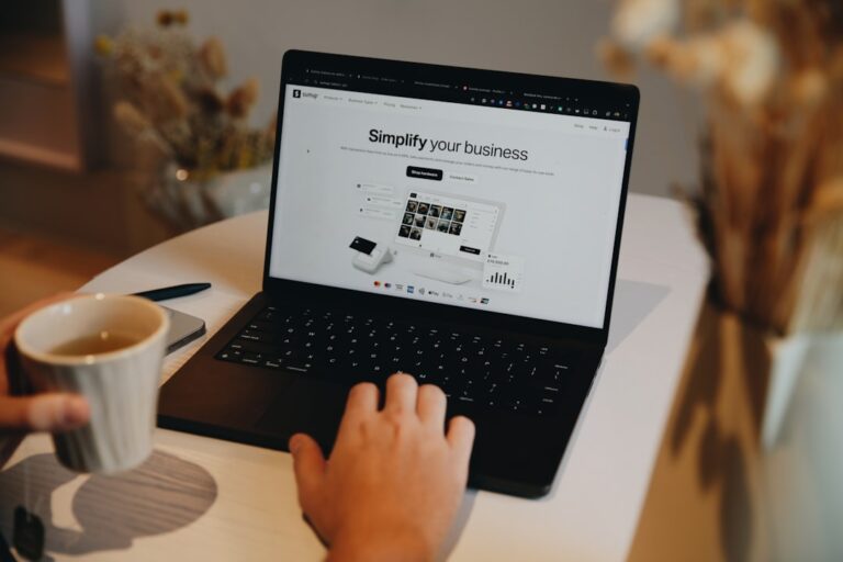 A person sitting at a table using a laptop computer